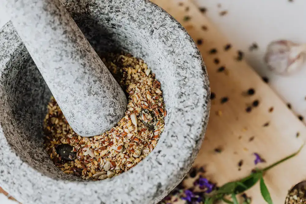 Grinding whole spices in a heavy stone mortar
